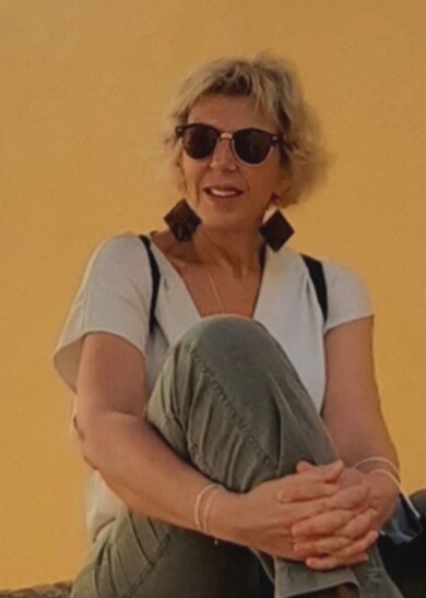 Nicole Fabre assise devant un mur ocre