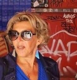 Nicole Fabre avec lunettes devant un fond graffiti rouge