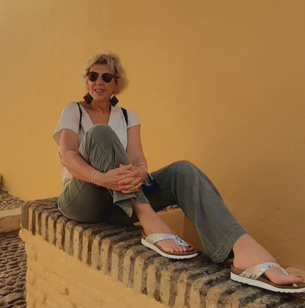 Nicole Fabre assise sur le mur ocre